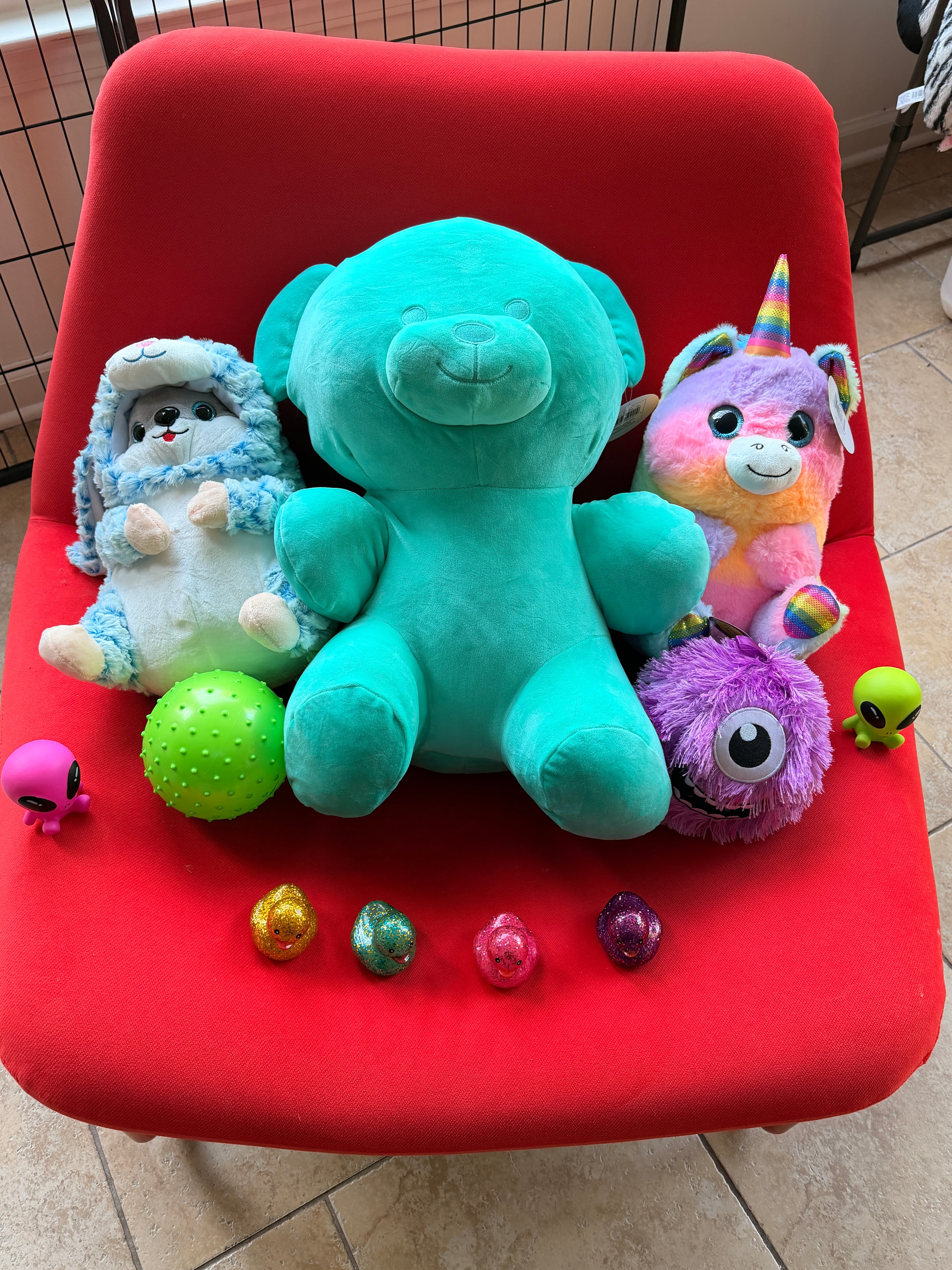 Collection of plush toys and prizes on a red chair